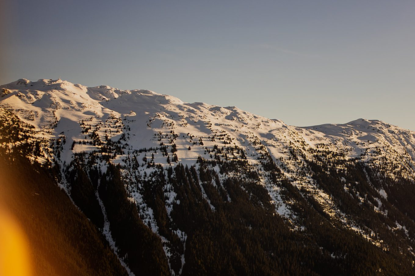 Snow-capped mountains covered in evergreen trees in British Columbia in Canada for blog post titled 10 ways to cope with and work through homesickness.